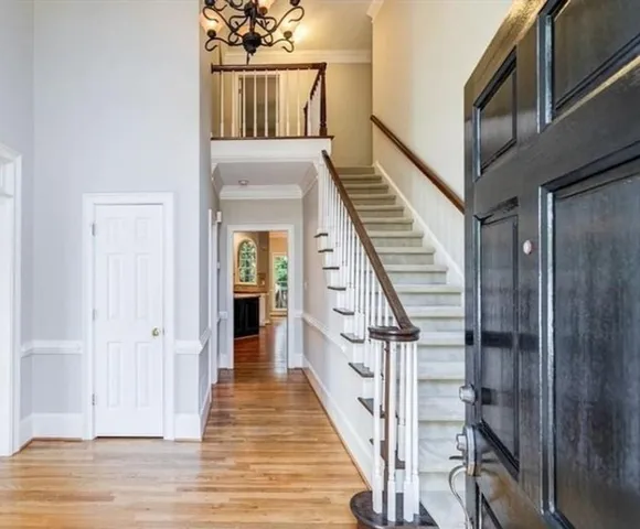 a view of a hallway with wooden floor and staircase