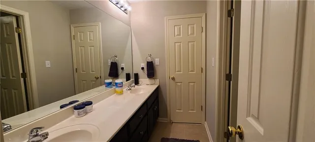 a bathroom with double vanity sink and a mirror