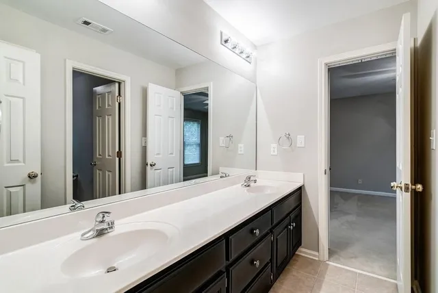 a bathroom with a double vanity sink and mirror
