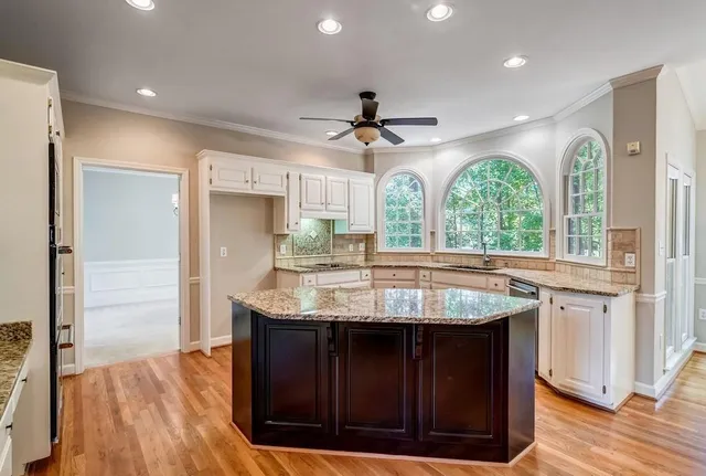 a kitchen with granite countertop a sink a counter top space and stainless steel appliances