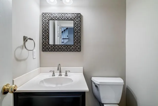 a bathroom with a toilet sink and mirror