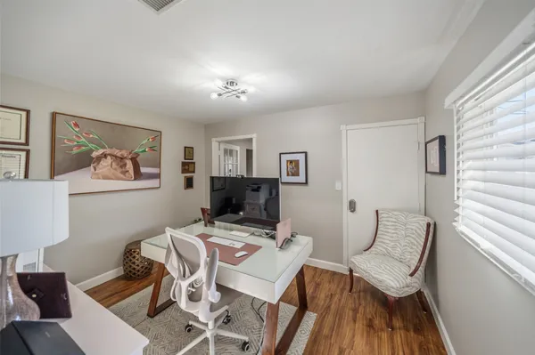 a view of a workspace with furniture and a window