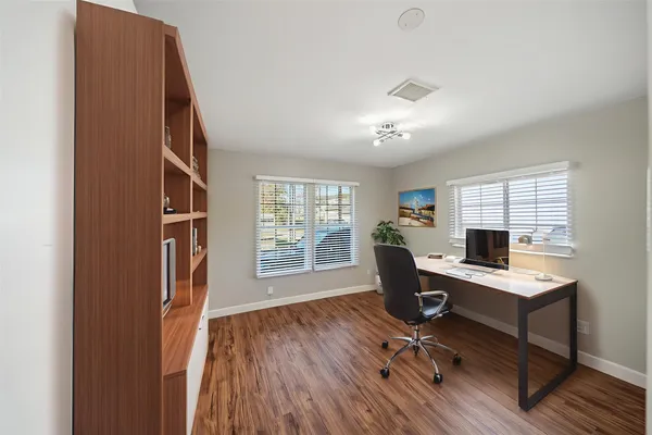 a view of a workspace with furniture and a window