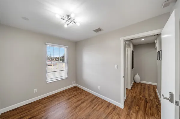 a view of a room with wooden floor and a ceiling fan