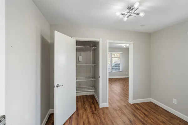 a view of empty room with wooden floor