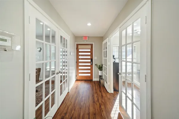 a view of a hallway with wooden floor and windows
