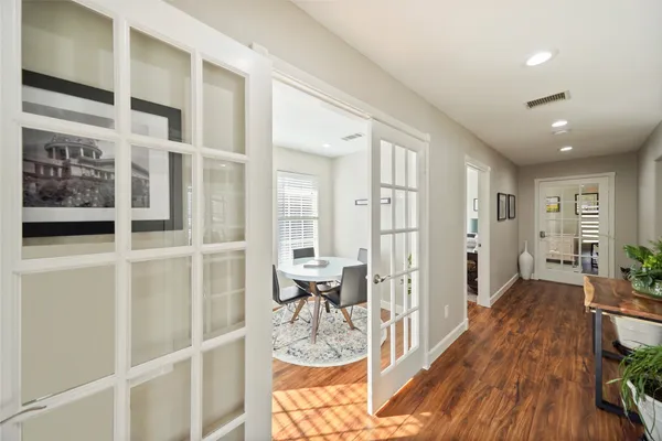 a view of a hallway with wooden floor and furniture