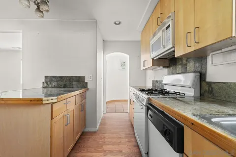 a kitchen with stainless steel appliances granite countertop a stove a refrigerator and a refrigerator