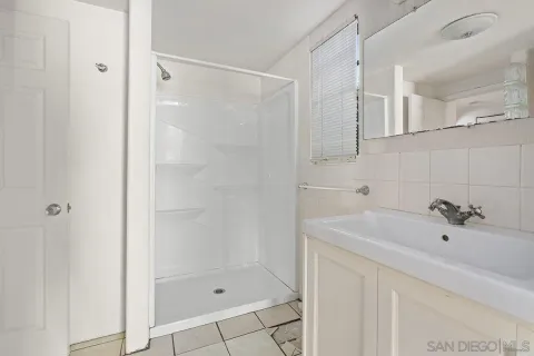 a view of bathroom with a sink mirror and window