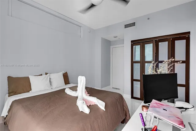 a bedroom with a bed and flat screen tv