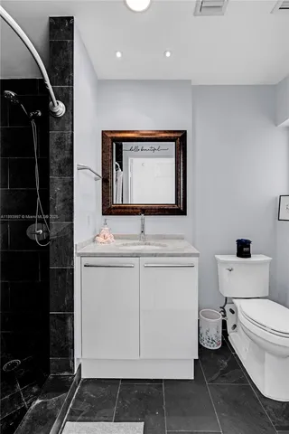 a bathroom with a toilet a sink and mirror