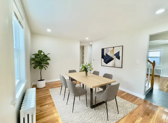 a view of a dining room with furniture wooden floor and a potted plant