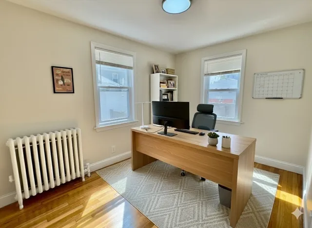a view of a workspace with furniture and a window