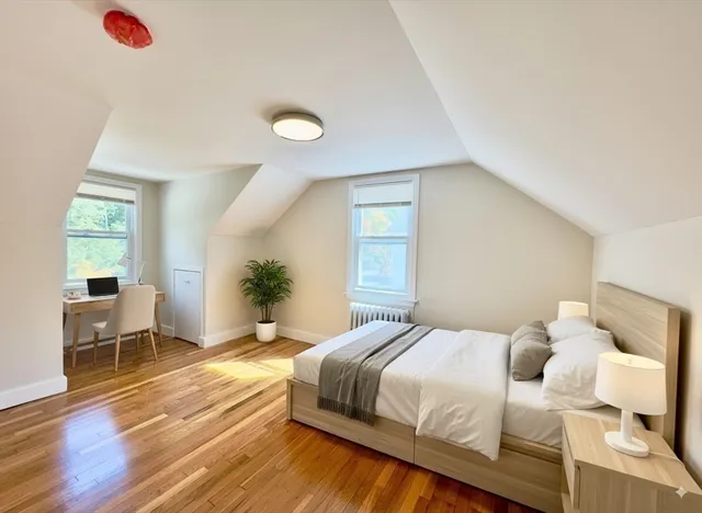 a bedroom with a bed and wooden floor