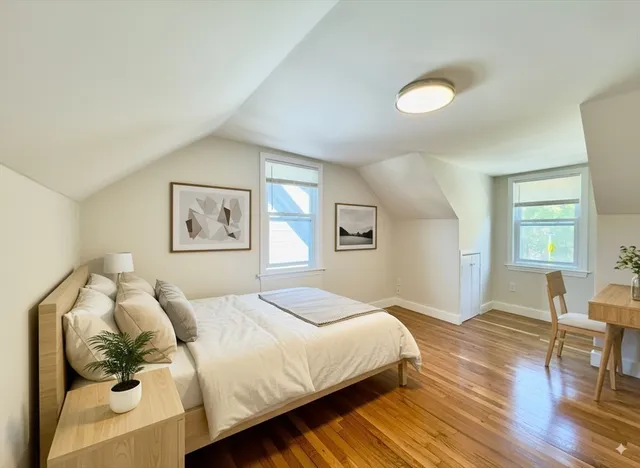 a bedroom with a bed and wooden floor