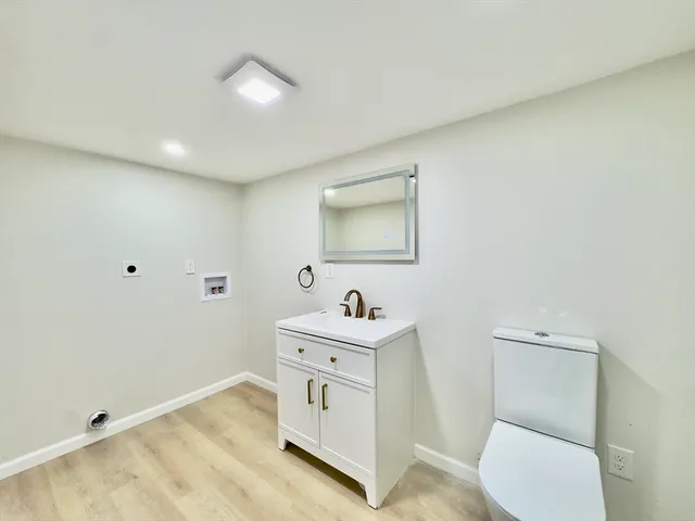 a bathroom with a sink toilet and mirror