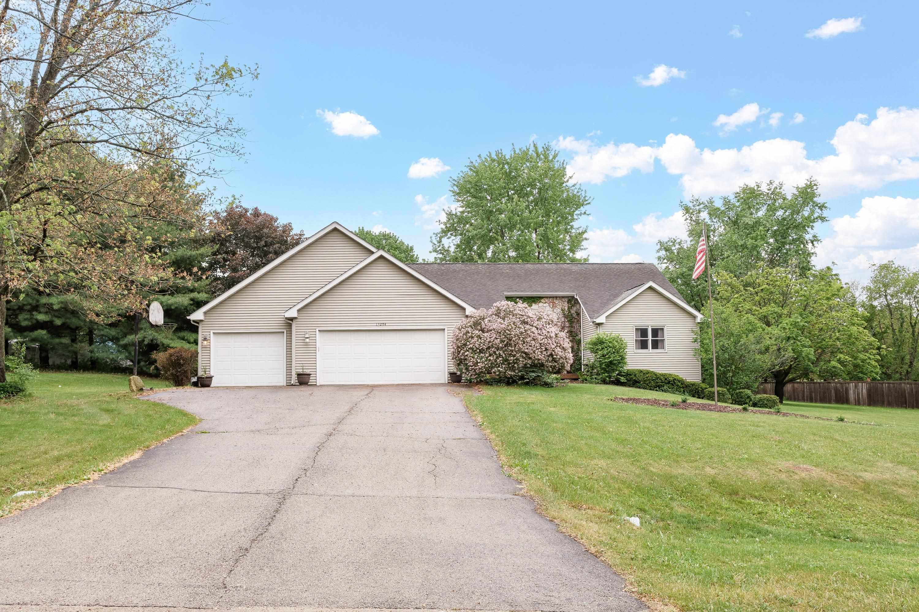 a view of a house with yard and a garden