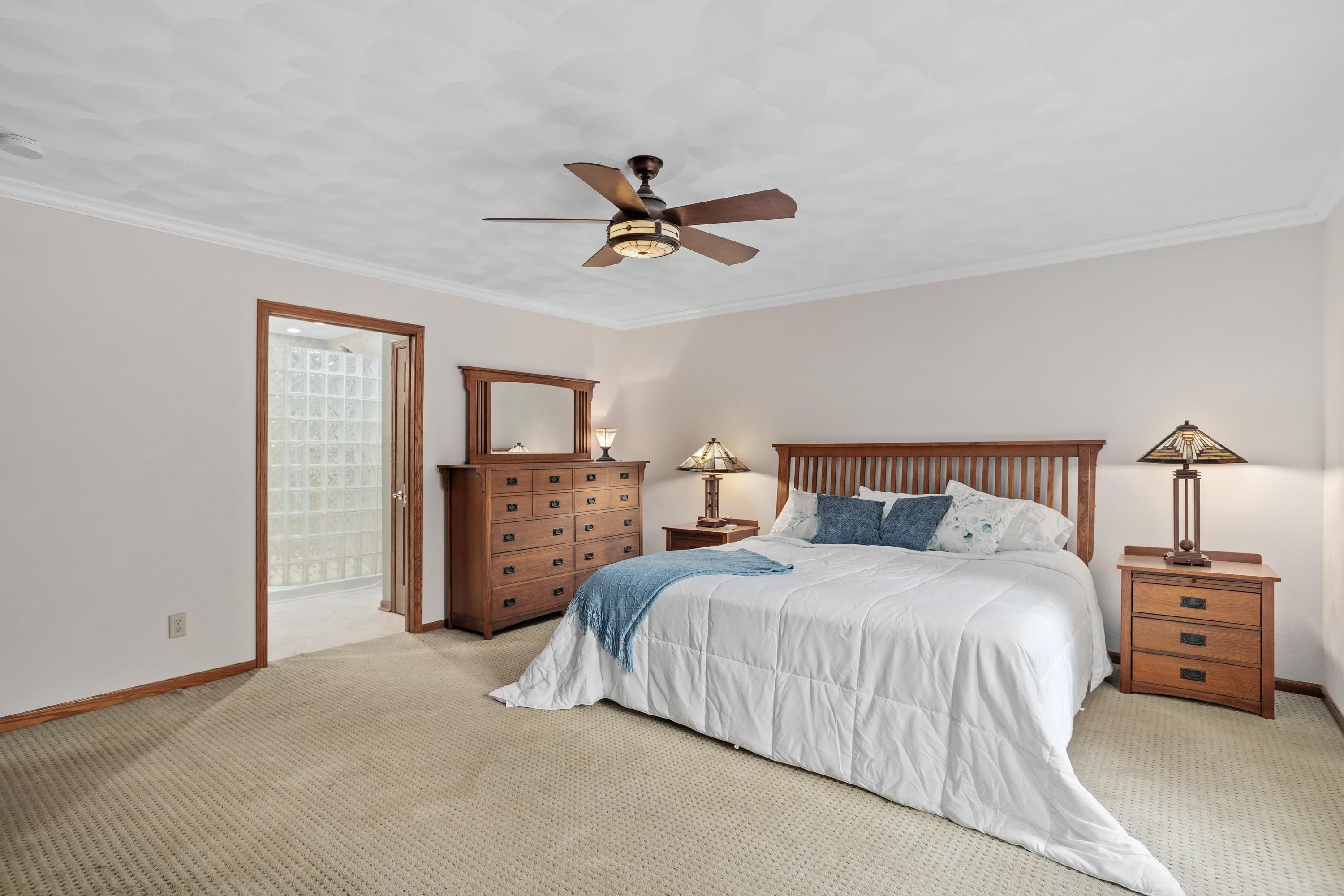 13294 Weatherfield Way Roscoe, IL 61073 - Photo 27 of 38 a bedroom with a bed a dresser and a chandelier
