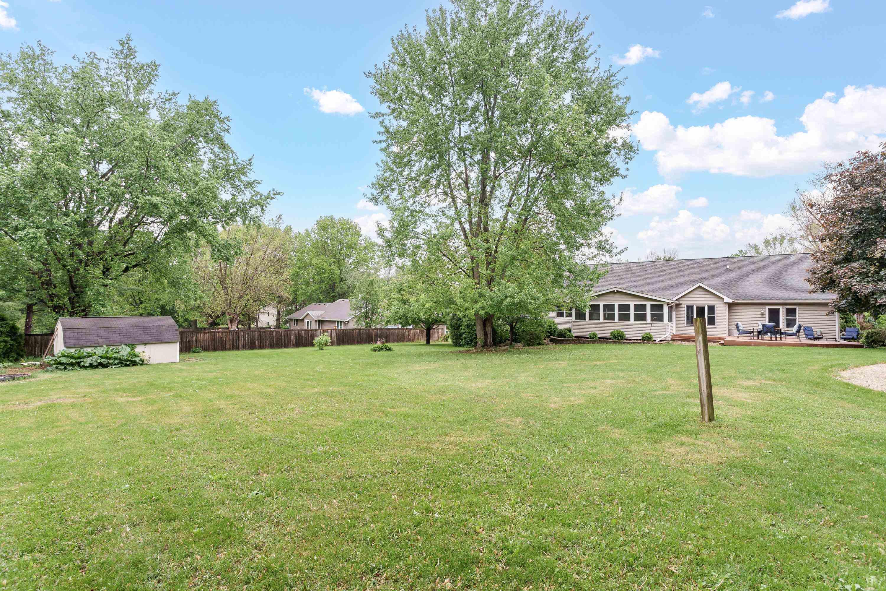 13294 Weatherfield Way Roscoe, IL 61073 - Photo 6 of 38 a view of a big house with a big yard and a large tree