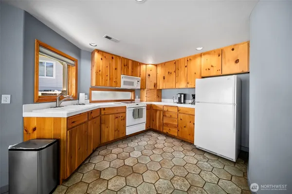 a kitchen with a sink refrigerator and cabinets