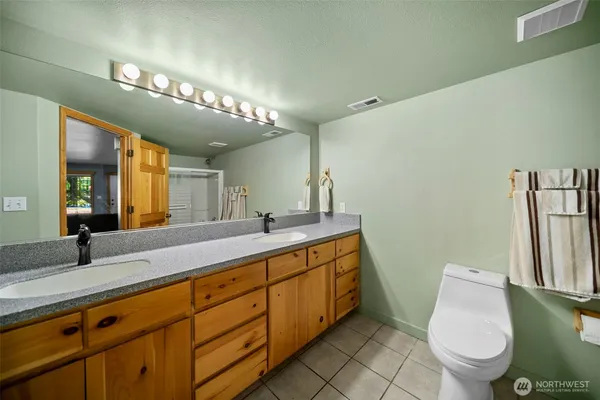 a bathroom with a toilet sink and mirror