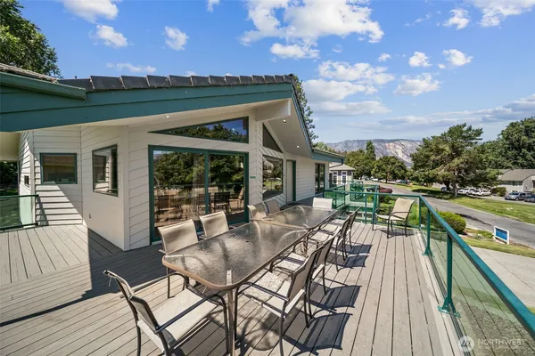 a view of a patio with table and chairs with wooden floor and fence