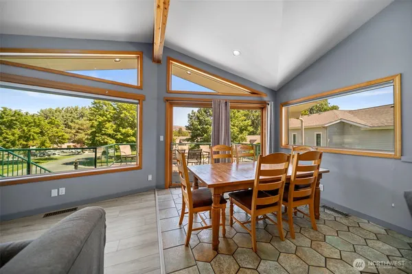 a dining room with furniture and large windows