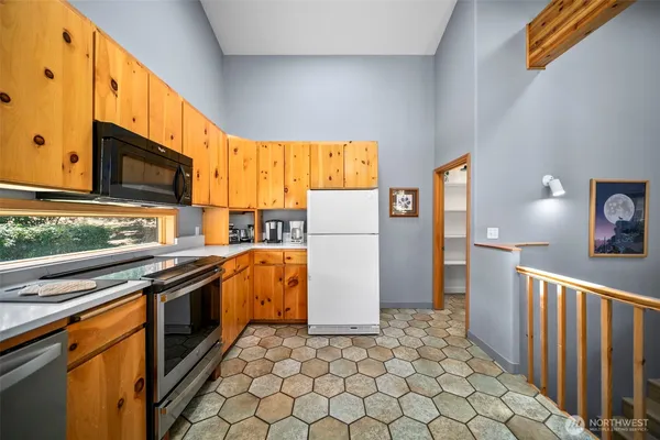a kitchen with a refrigerator a stove top oven a sink and dishwasher