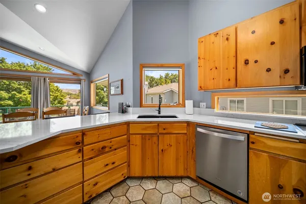 a kitchen with stainless steel appliances granite countertop a sink and a large window
