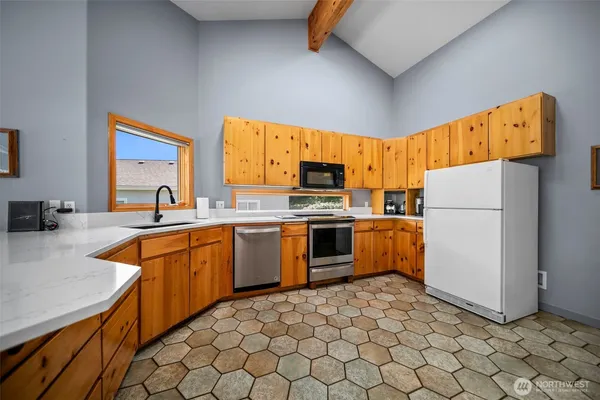 a kitchen with a sink refrigerator and cabinets