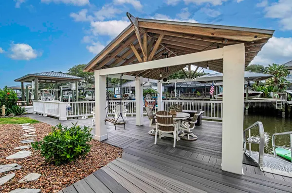a patio with wooden floor a yard a table and chairs
