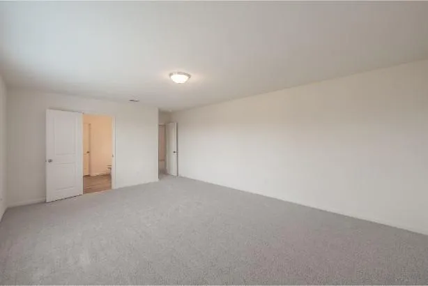 a spacious bathroom with a toilet sink and mirror