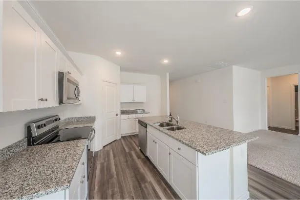 a kitchen with granite countertop a sink and wooden floor