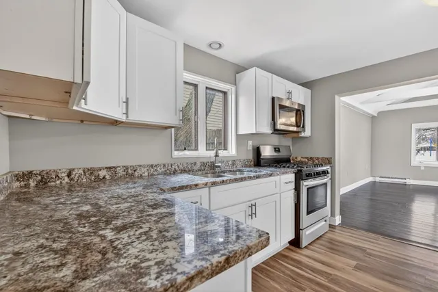 a kitchen with stainless steel appliances granite countertop a stove a sink and a microwave
