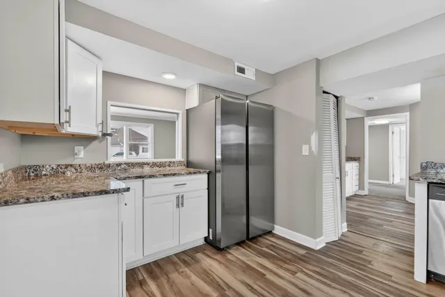 a kitchen with stainless steel appliances granite countertop a refrigerator and a stove top oven