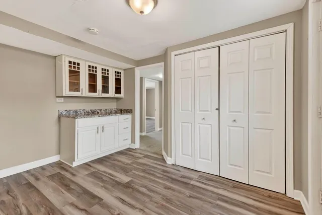 a view of a kitchen with white cabinets and wooden floor