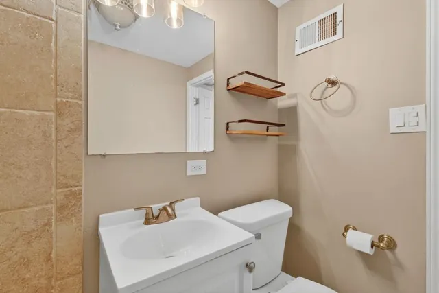 a bathroom with a sink mirror and toilet