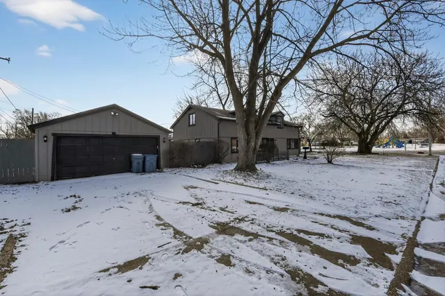 a front view of a house with a yard covered in snow