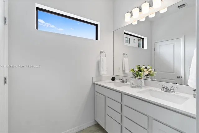 a bathroom with a double vanity sink and mirror
