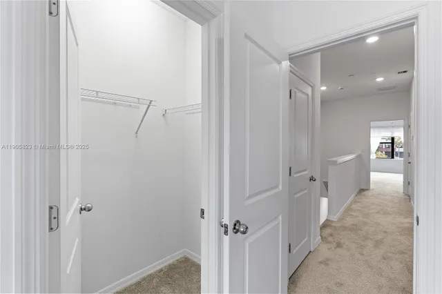 an empty room with a window and a chandelier fan