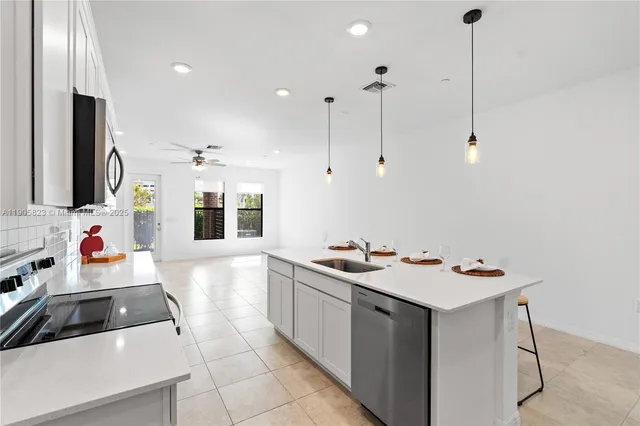 a view of kitchen with stainless steel appliances granite countertop cabinets and sink