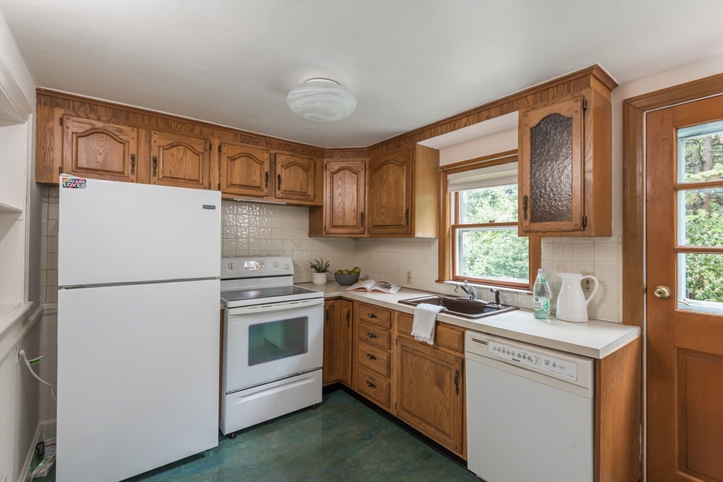 67 Smith Street Arlington, MA 02476 - Photo 10 of 32 a kitchen with a sink a refrigerator a window and cabinets