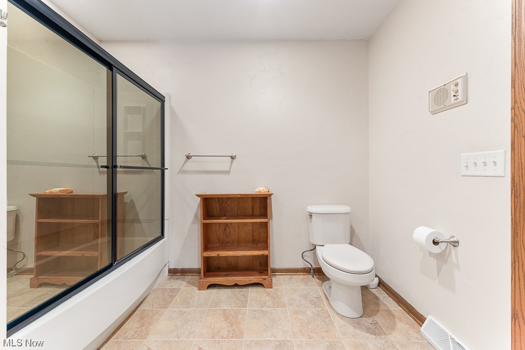19235 West Middletown Road Beloit, OH 44609 - Photo 26 of 35 Bathroom featuring shower / bath combination with glass door and light tile floors