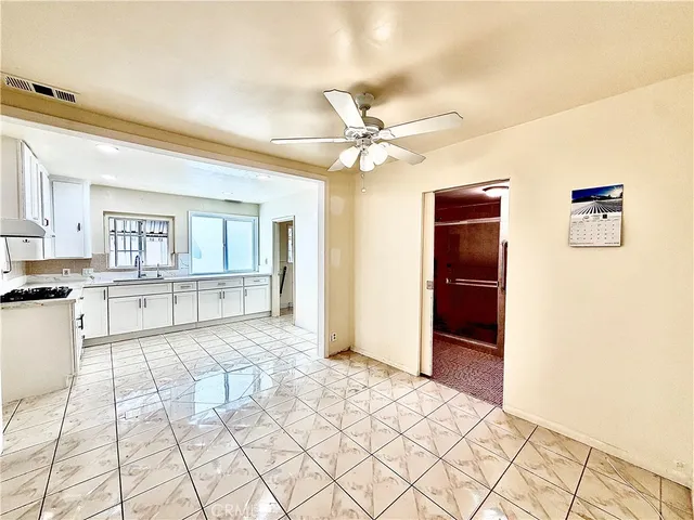 a view of a hallway with a chandelier fan and wooden floor