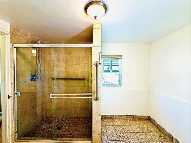 a view of a big room with a chandelier fan and a bathroom