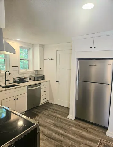 a kitchen with a refrigerator sink and cabinets