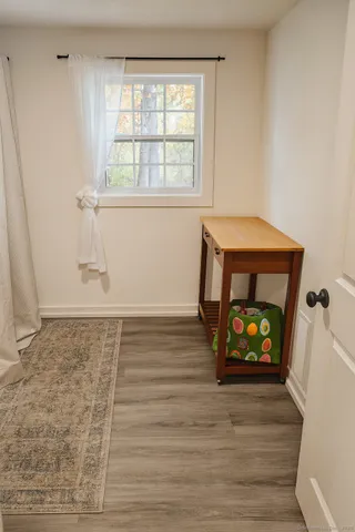 an empty room with wooden floor a fireplace and windows