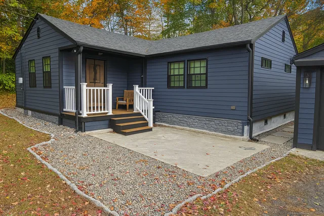 a backyard of a house with barbeque oven and wooden floor