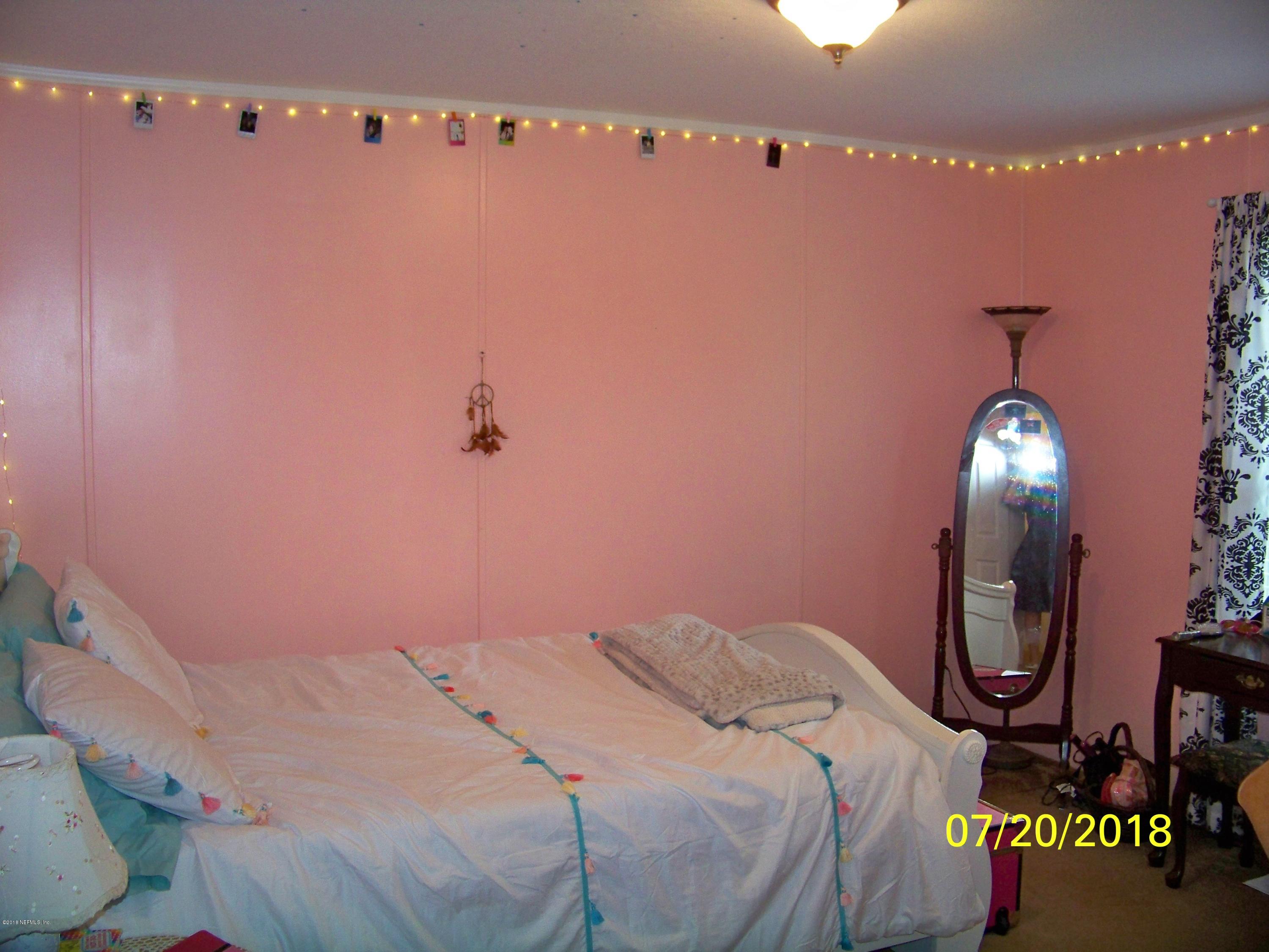 54314 Lawhon Road West Callahan, FL 32011 - Photo 16 of 30 a bedroom with a bed and a mirror