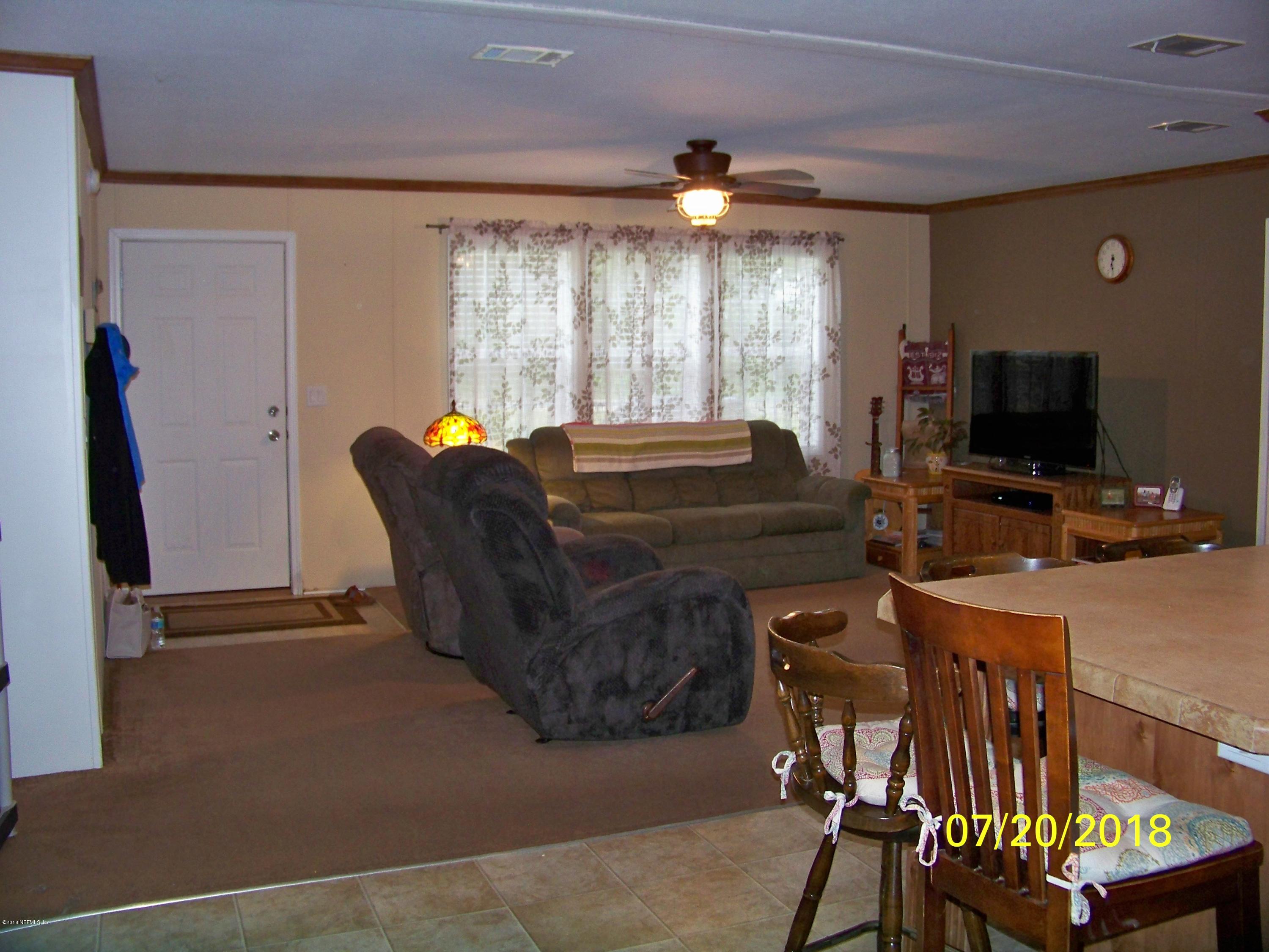 54314 Lawhon Road West Callahan, FL 32011 - Photo 4 of 30 a living room with furniture a flat screen tv and a large window
